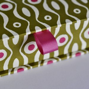 detail of Postcard Box covered in Persephone Bright Olive and Cool Pink paper by Cambridge Imprint